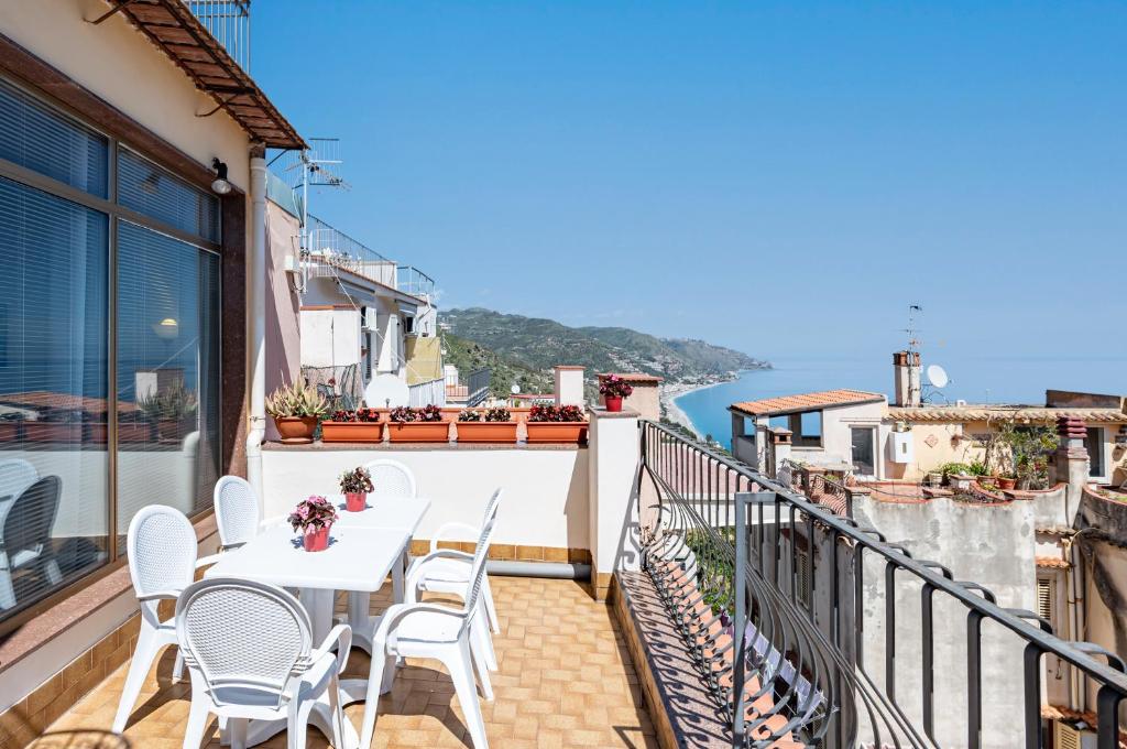 balcón con mesa, sillas y vistas al océano en A Look of Taormina Apartments - a Few Steps from the Center, en Taormina