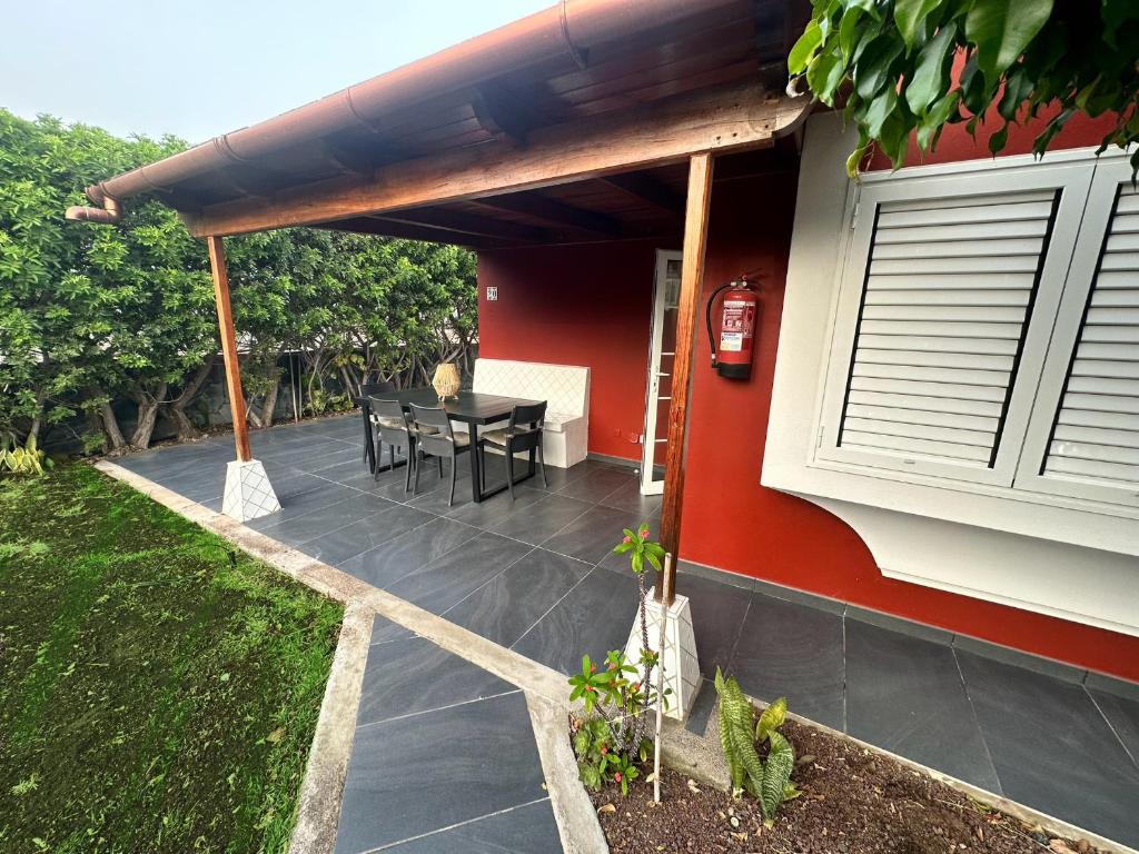 une terrasse avec une table et une maison dans l'établissement Bungalow the Paradise, à Maspalomas