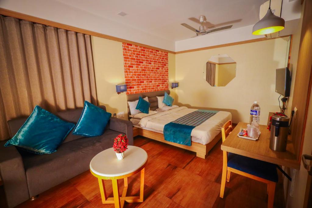 une chambre d'hôtel avec un lit et un canapé dans l'établissement HOTEL EVERLAND, à Rajkot