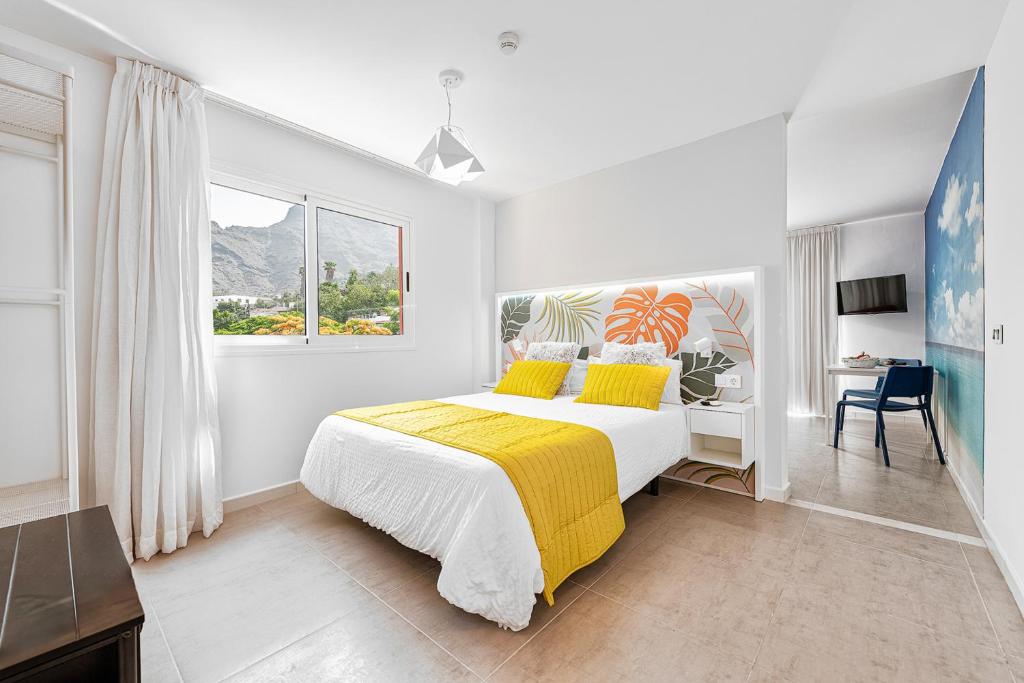 ein Schlafzimmer mit einem Bett mit einer gelben Decke in der Unterkunft Sol Mogan Suites - Adults Only in Puerto de Mogán
