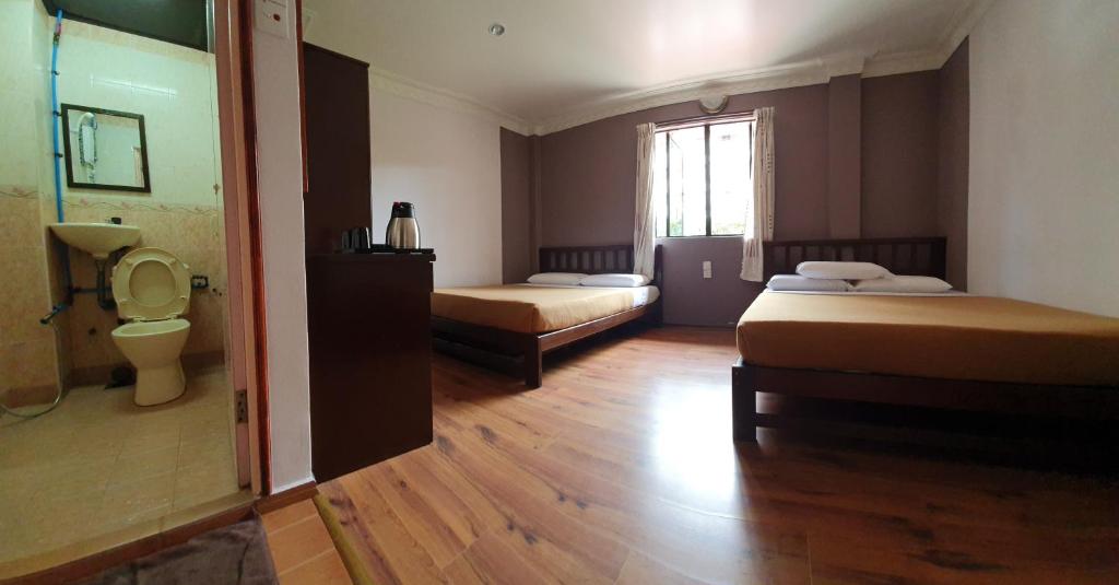 um quarto com 2 camas, um WC e uma janela em Hotel Sentosa em Brinchang