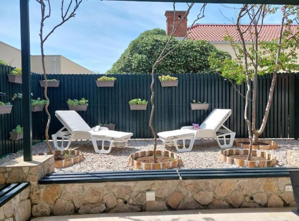 a patio with two white chairs and two trees at Chill apartment in Dubrovnik