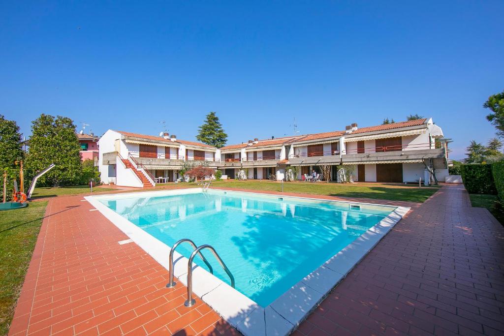 a swimming pool in front of a building at Cinzia Apartment Front Beach - Happy Rentals in Sirmione