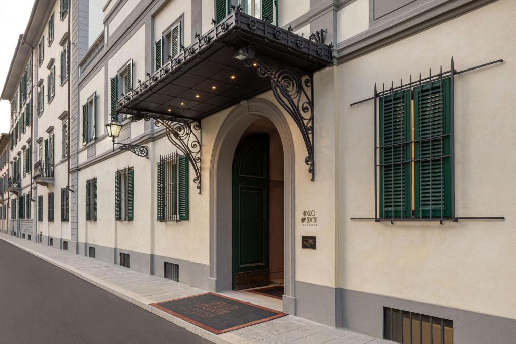 einen Eingang zu einem Gebäude mit grüner Tür in der Unterkunft Anglo American Hotel Florence, Curio Collection By Hilton in Florenz