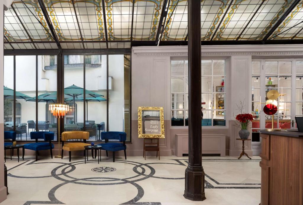 una hall con sedie e tavoli in un edificio di Anglo American Hotel Florence, Curio Collection By Hilton a Firenze