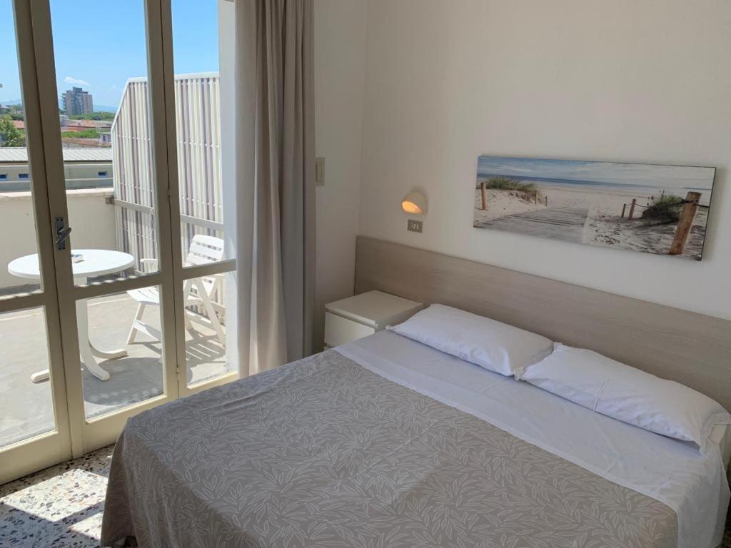 a bedroom with a bed and a view of the beach at B&B Via Mare in Milano Marittima