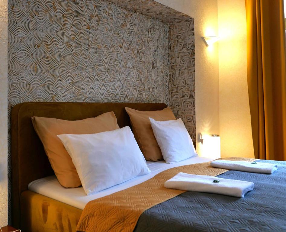 ein Bett mit zwei weißen Kissen und zwei Ordnern in der Unterkunft Hotel Radnice in Liberec