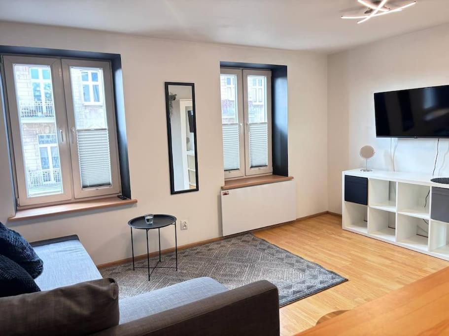 ein Wohnzimmer mit einem Sofa und einem Flachbild-TV in der Unterkunft Lokal typu Studio 66 in Łódź