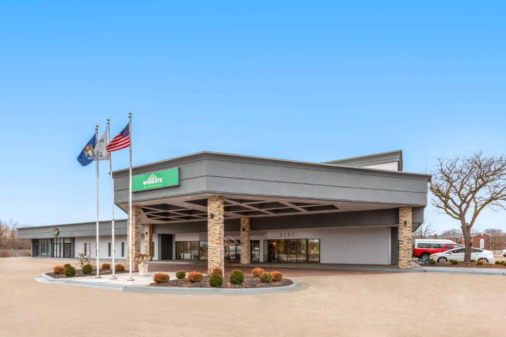 an office building with an american flag in front of it at Wingate by Wyndham Troy in Troy