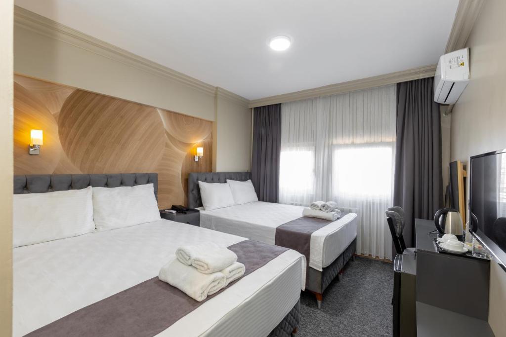 a hotel room with two beds and a television at Loyal City The Best Hotel in Bursa in Bursa