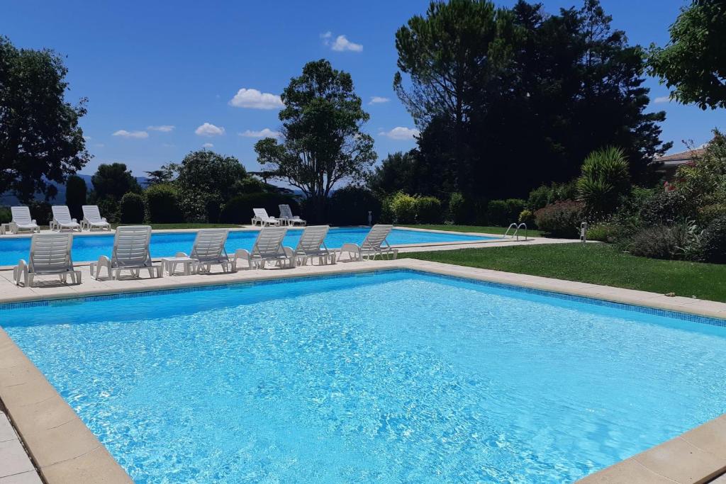 une grande piscine avec des chaises dans l'établissement Appartement Angelin - Welkeys, à Aix-en-Provence