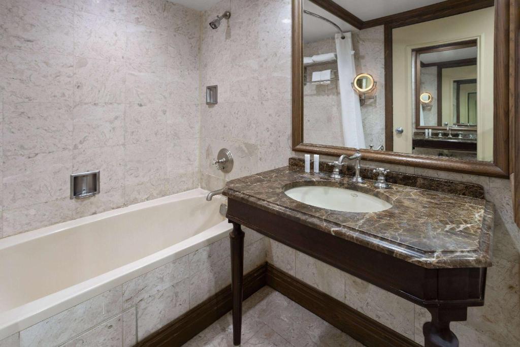 紐約的住宿－The Blakely by LuxUrban，一间带水槽、浴缸和镜子的浴室
