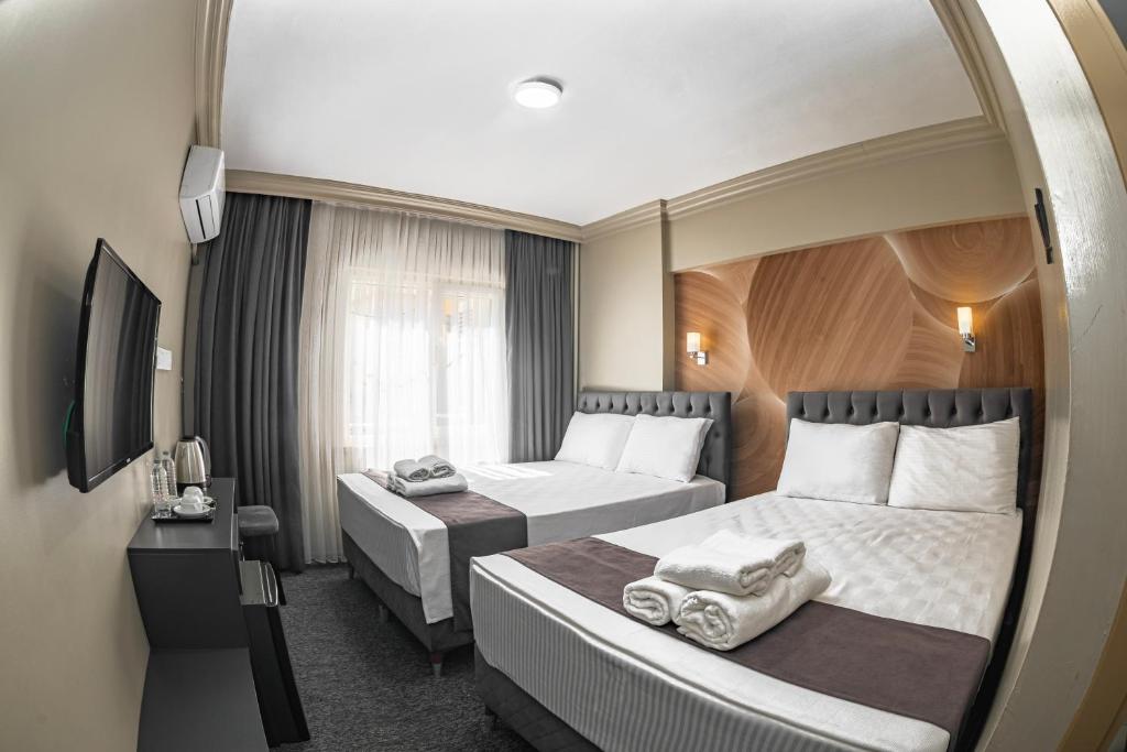 a hotel room with two beds and a mirror at BURSA LOYAL CiTY HOTEL & SPA in Bursa