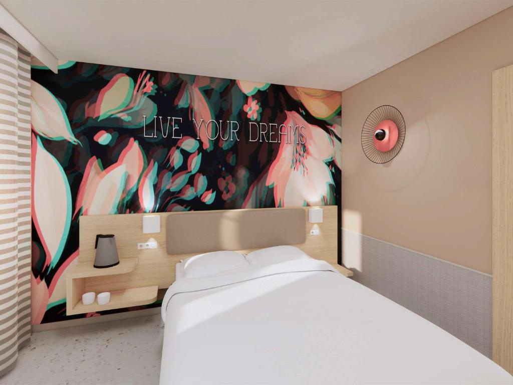 a bedroom with a bed with a painting on the wall at ibis Styles Bordeaux Centre Gare in Bordeaux