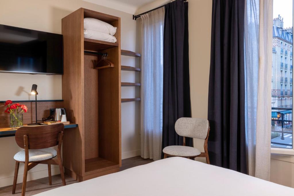 a hotel room with a bed and a desk and a room at Bijou Hôtel Paris Boulogne in Boulogne-Billancourt
