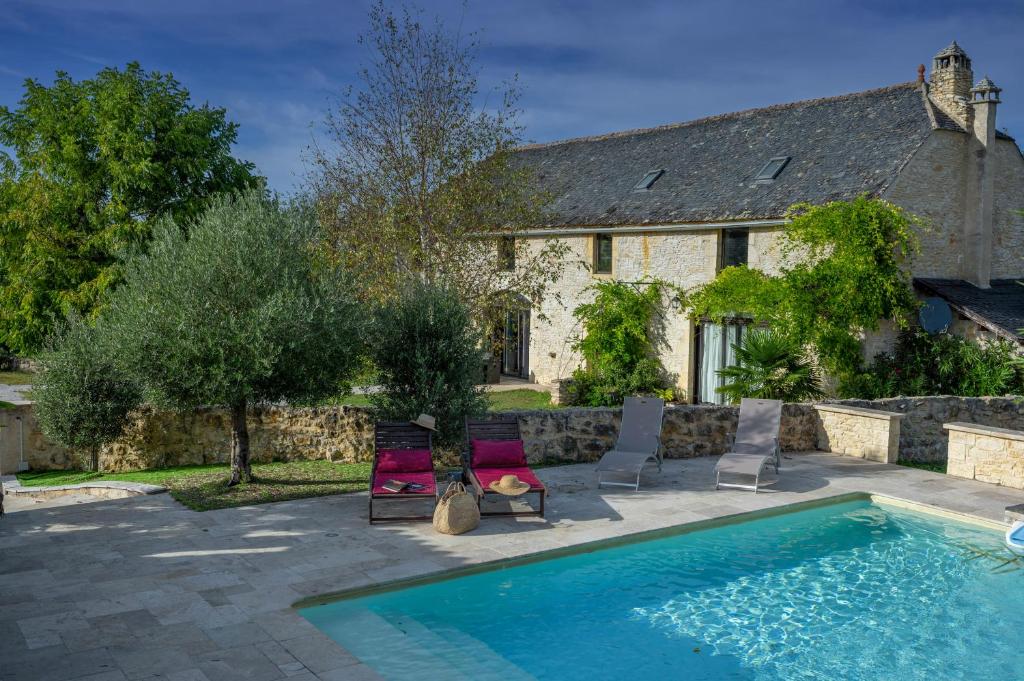 a house with a swimming pool in front of a house at Le Havre de Paix en Périgord in La Cassagne