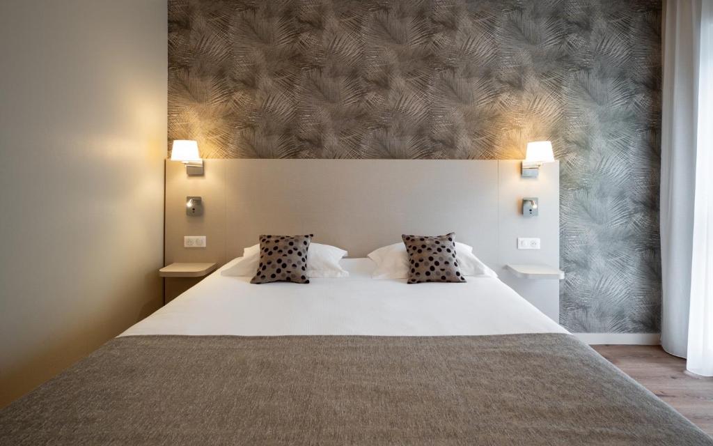 Postel nebo postele na pokoji v ubytování Kyriad Prestige Saint-Malo