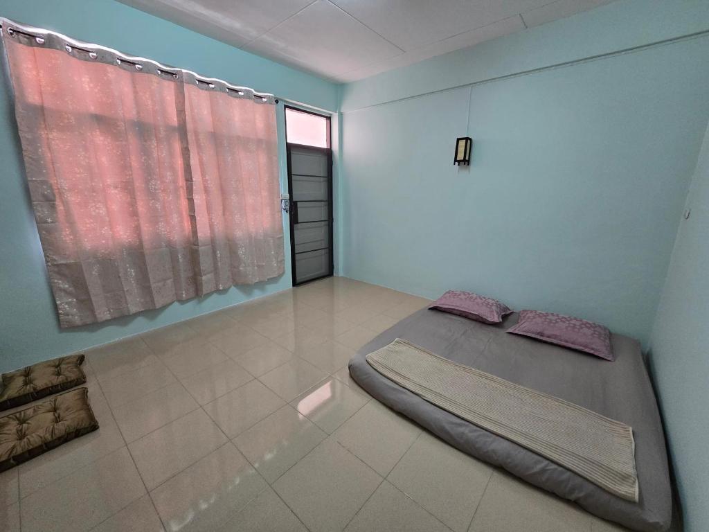 a bedroom with a bed and a large window at Yume House in Hat Yai