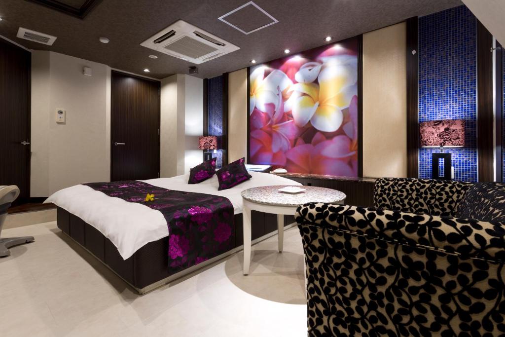 1 dormitorio con 1 cama, mesa y sillas en もしもしピエロ NEO 京都店, en Kioto