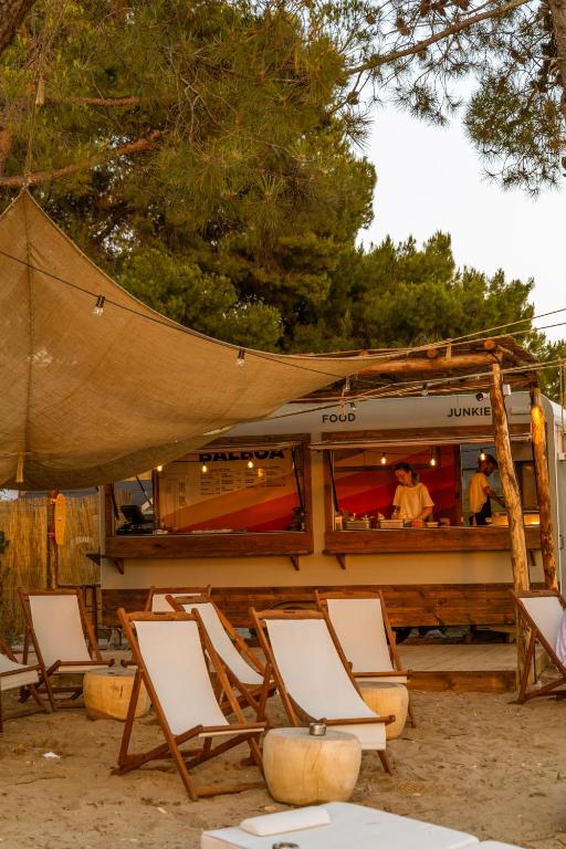 a group of chairs sitting in front of a food truck at Ergon Beach House Nikiti in Nikiti