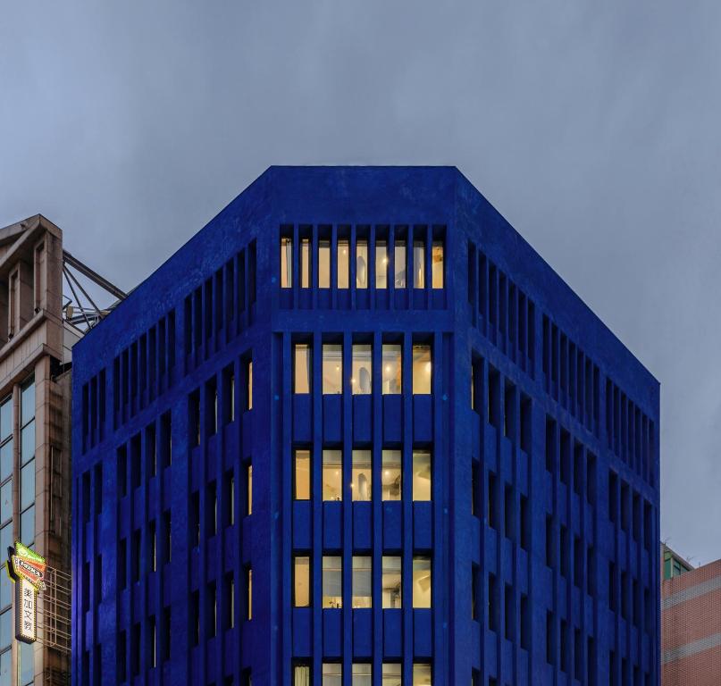 台北的住宿－正旅館 藍，蓝色的办公楼,窗户上有灯