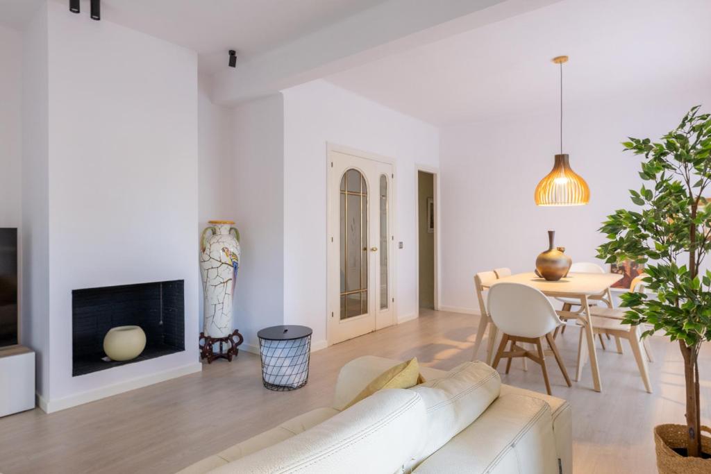 a living room with a white couch and a table at Stay Barcelona Long Term Camp Nou in Barcelona