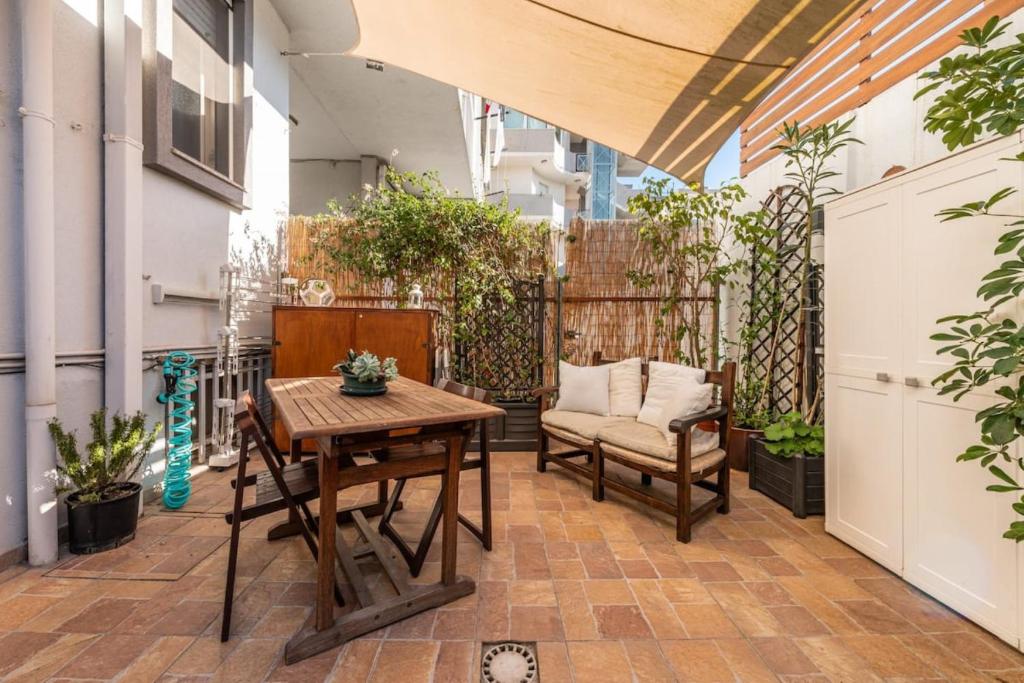 une terrasse avec une table, des chaises et des plantes dans l'établissement House Roberta - Green Oasis in the City, à Cagliari