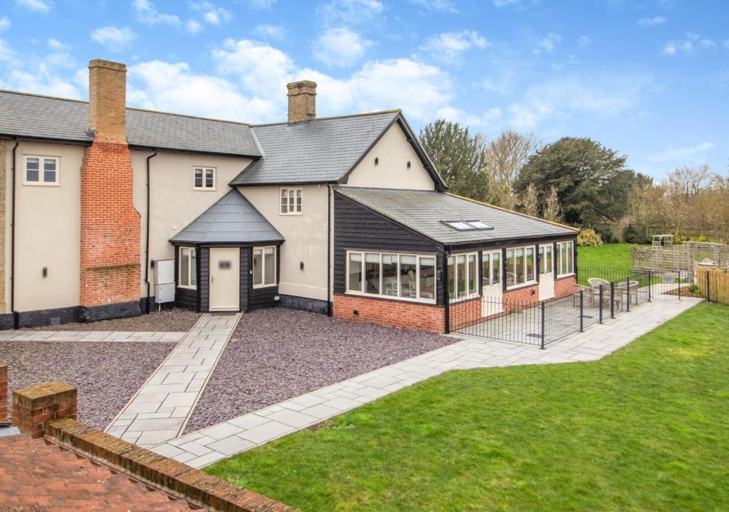 une grande maison en briques avec une grande cour dans l'établissement White House Lodges - Dragonfly, à Heveningham