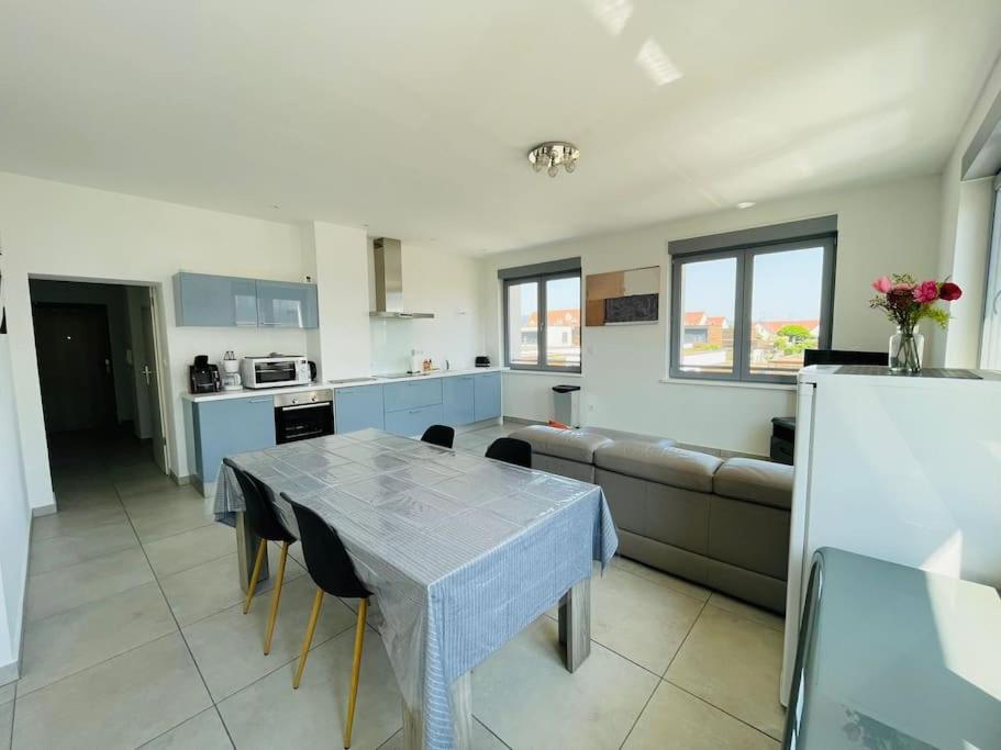 une cuisine et un salon avec une table et un canapé dans l'établissement Les Cotonnades (Colmar), à Wintzenheim