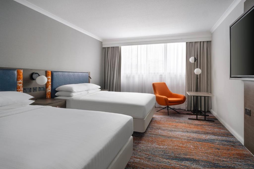 una habitación de hotel con 2 camas y una silla en Glasgow Marriott Hotel, en Glasgow