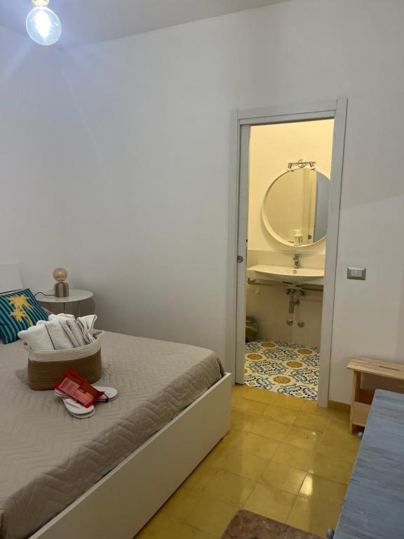 a bedroom with a bed and a bathroom with a mirror at Casa San Domingo in Marina di Camerota