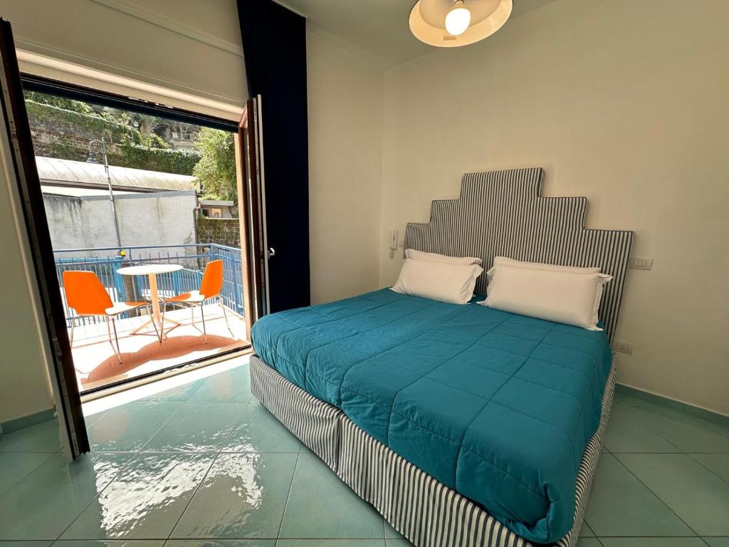 a bedroom with a bed and a balcony with a table at Il Sirenio in Sorrento