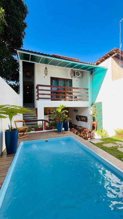 a swimming pool in front of a house at Pousada Bilica - Centro in Arraial d'Ajuda