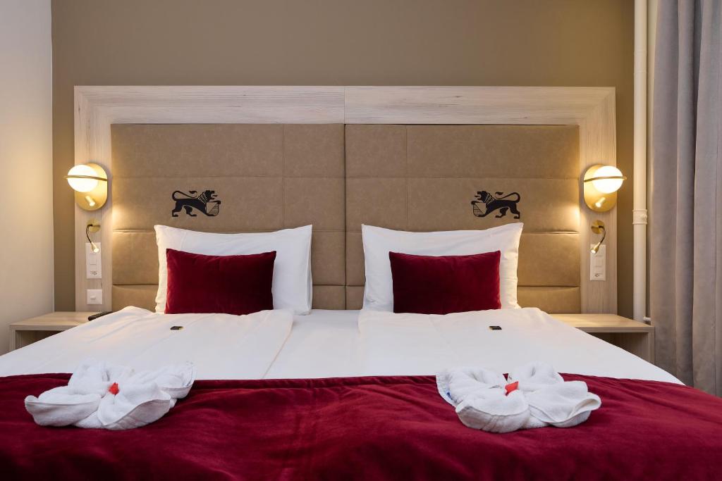 a bedroom with a large bed with two towels on it at Hotel St.Gotthard in Zürich