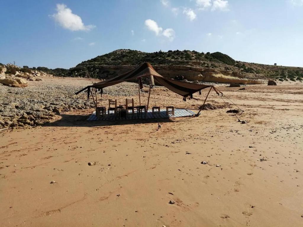 a tent on a beach with chairs on it at sidi kaouki ayt karoum in Sidi Kaouki