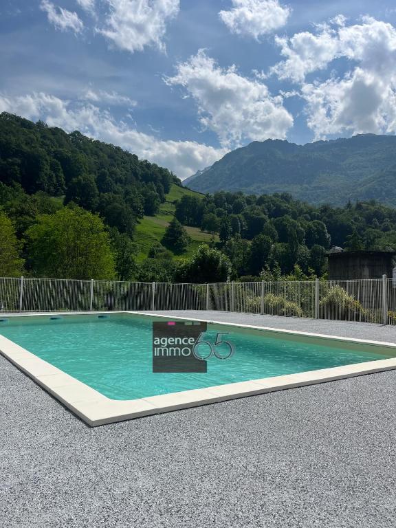 a swimming pool with mountains in the background at Résidence Pyrénées Zenith in Luz-Saint-Sauveur
