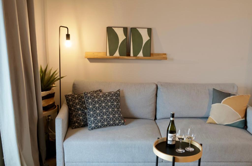 een woonkamer met een bank en een tafel met een fles wijn bij Capital Towers Prime in Rzeszów