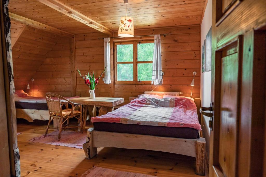 sypialnia z łóżkiem i stołem w kabinie w obiekcie U Prezesa w mieście Lutowiska