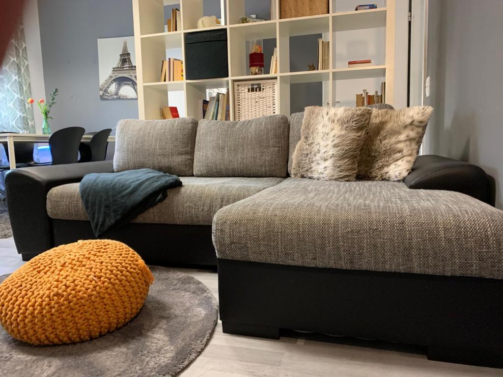 a living room with a couch and a ottoman at Neu Studio Leipzig Zentrum in Leipzig