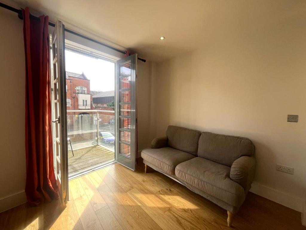 a living room with a couch and a large window at Harbourside Haven - One Bed Apartment with Balcony in Bristol