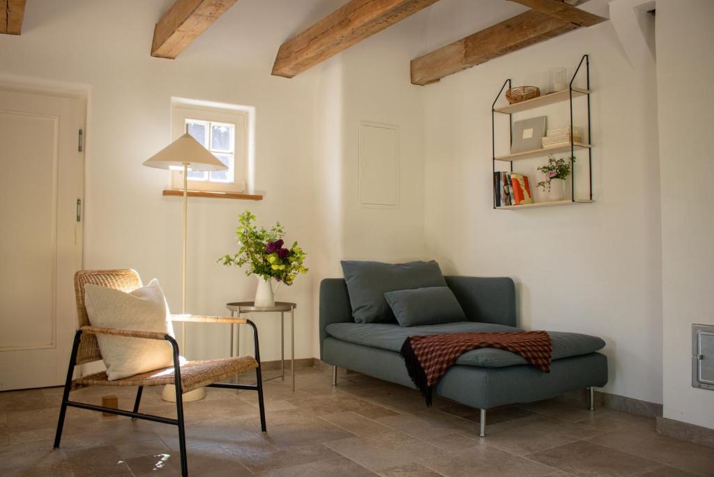 a living room with a blue couch and a chair at Idyllisches Landhaus, Garten & Kaminofen, perfekt für Paare in Häven