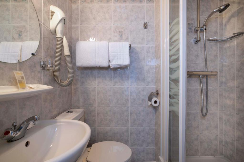 a bathroom with a shower and a sink and a toilet at Bijou Hôtel Paris Boulogne in Boulogne-Billancourt