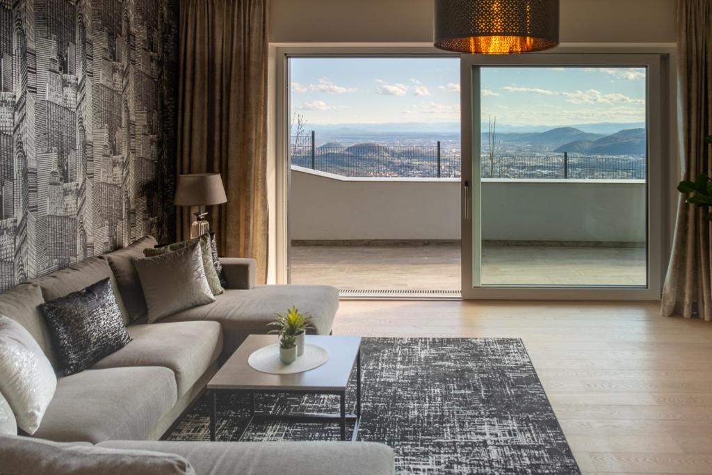 ein Wohnzimmer mit einem Sofa und einem Tisch in der Unterkunft Apartment Skyline Graz Villa Stattegg in Stattegg