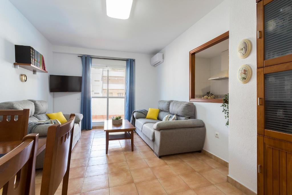 a living room with a couch and a table at Laguna 3 Rooms Piscina in Chipiona