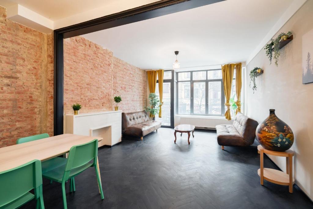 a living room with a brick wall and a table and chairs at Charming and Spacious Apartments in the Heart of Antwerp in Antwerp