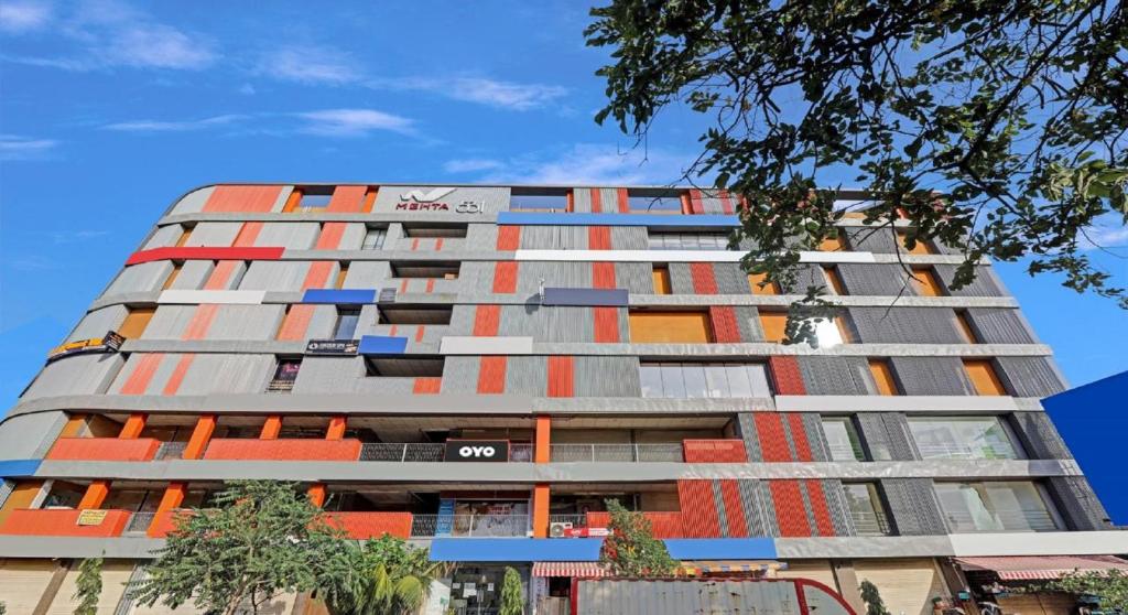 a tall apartment building with red and orange windows at Hotel Planet Villa in Ahmedabad