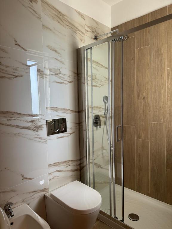 La salle de bains est pourvue de toilettes et d'une douche en verre. dans l'établissement Hotel Airone, à Alberobello
