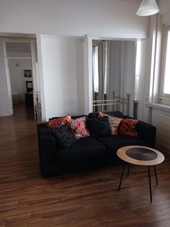 a living room with a black couch and a table at Anne's City Apartment in Jyväskylä