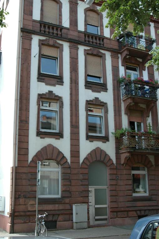 ein großes Backsteingebäude mit Fenstern und einem Fahrrad, das vorne geparkt ist in der Unterkunft ApartInn in Mannheim
