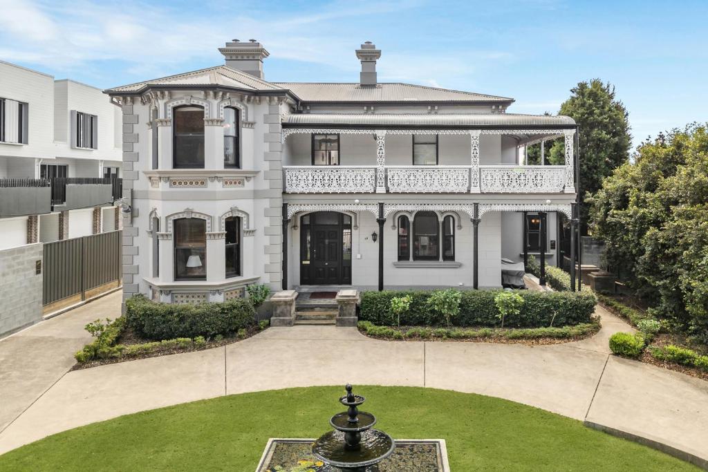 a large white house with a fountain in the yard at The Mansion in Hamilton